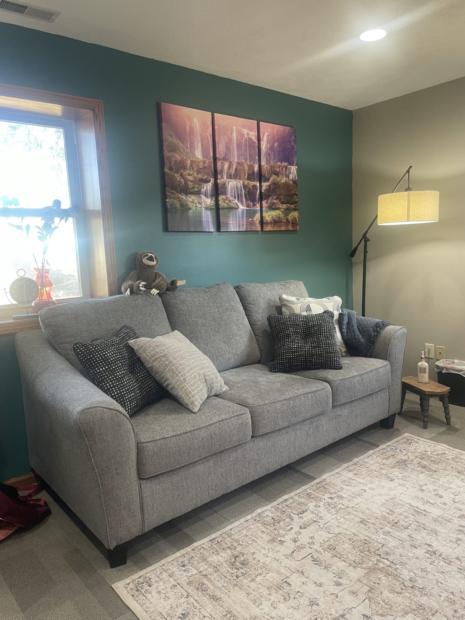 A living room with a couch and pillows on the floor